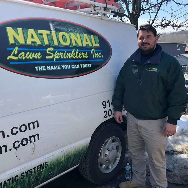 Anthony Luciano beside a National Lawn service van.