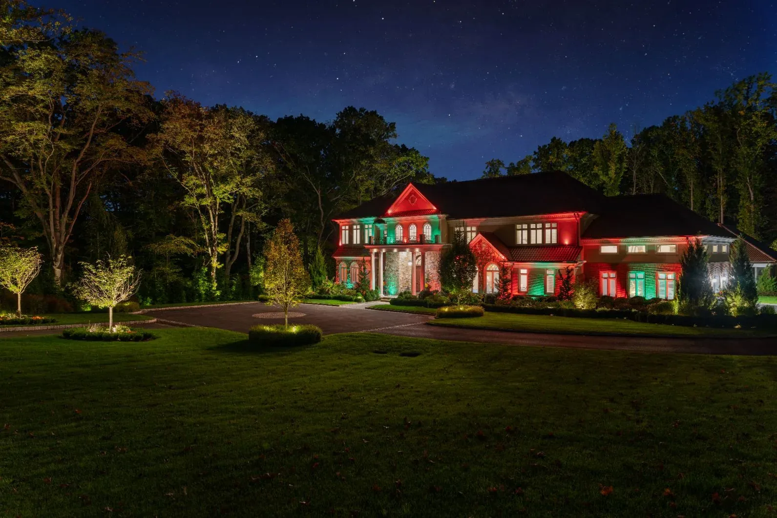 House facade illuminated in red and green at night.