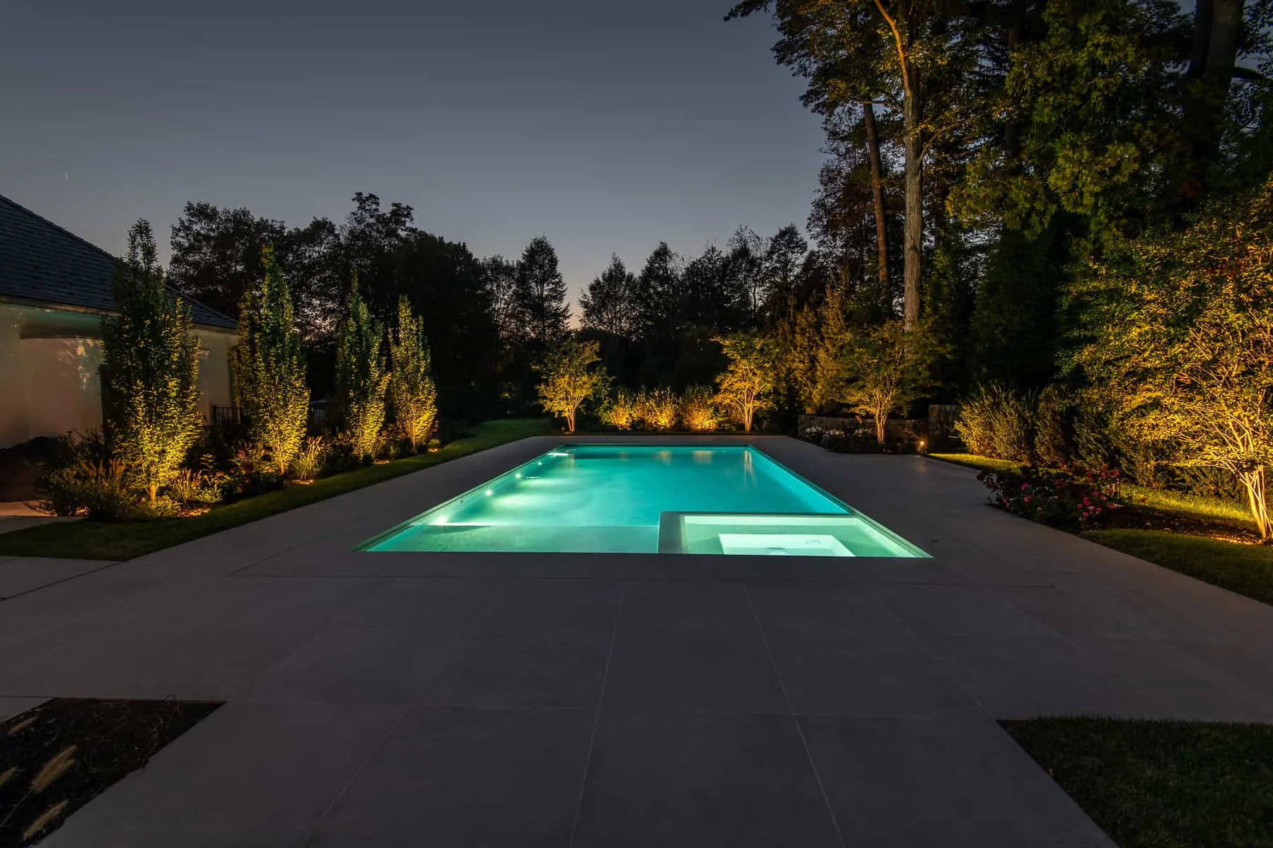 Landscape lighting surrounding the pool at Modern Greenwich Estate.