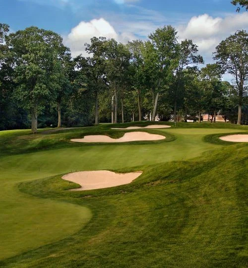 Original course photograph of a tree-lined Nissequogue green and its surrounding bunkers.
