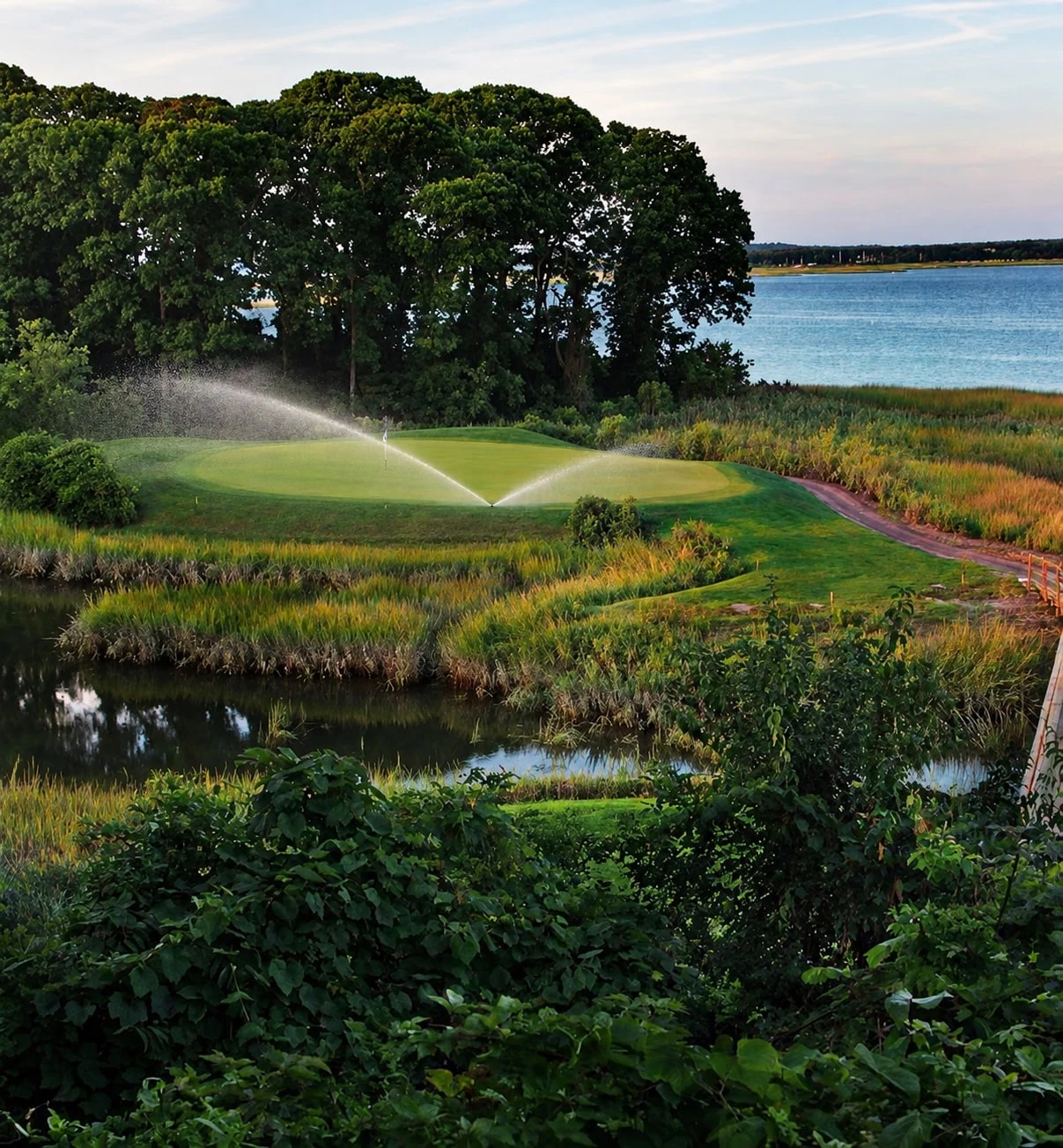 AI-edited view of Nissequogue’s marsh-side green and bay, with irrigation added at the green collar.