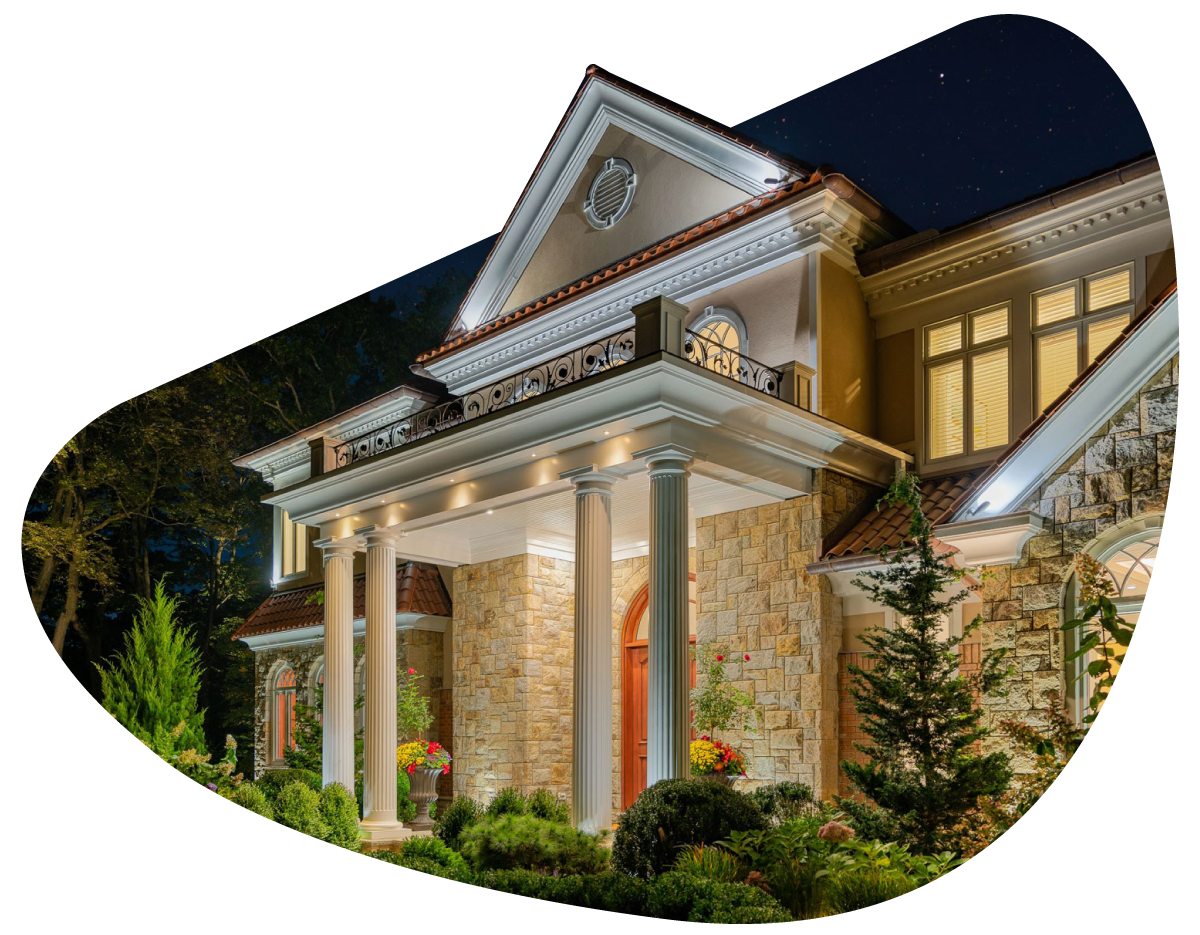 Original lighting artwork showing an illuminated stone house and garden after dark.